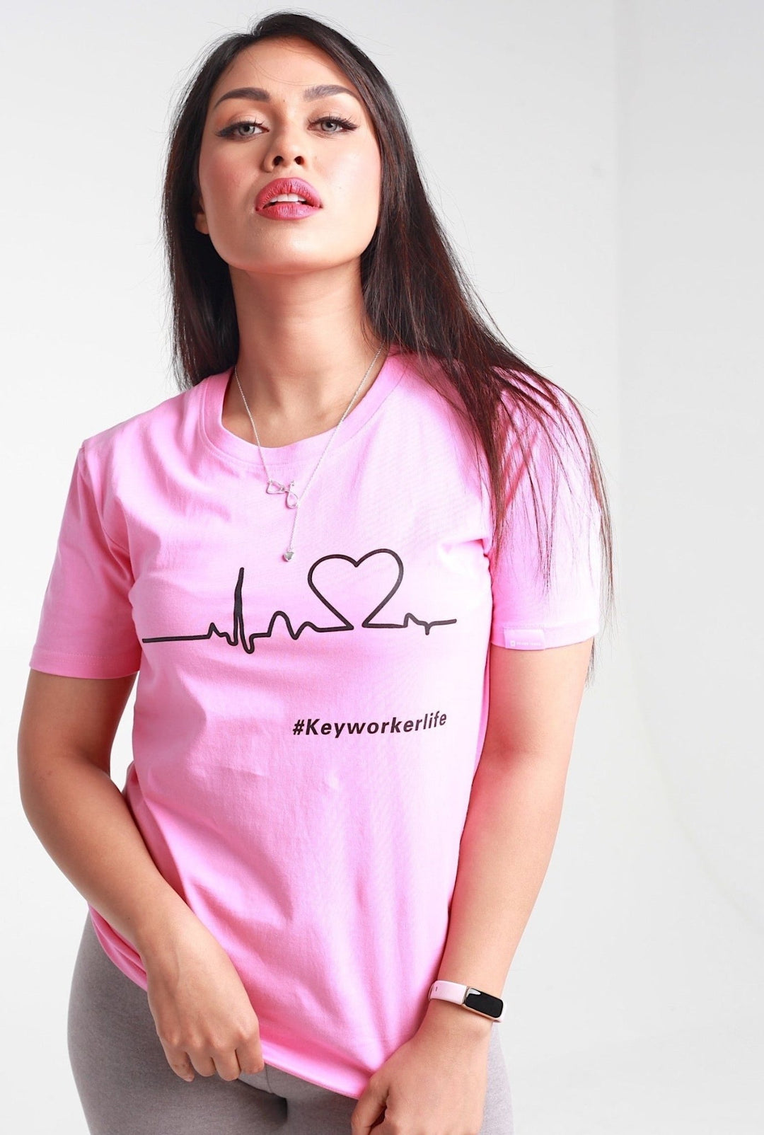 A pink t-shirt with a heartbeat line graphic forming a heart and the hashtag "#Keyworkerlife," representing the healthcare profession.