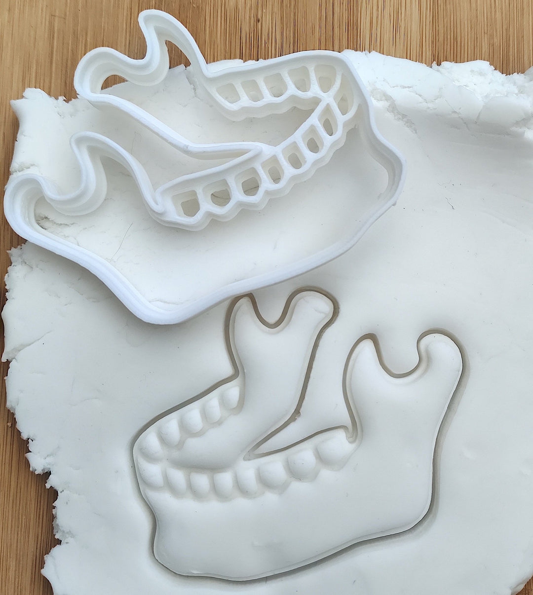 Jaw bone and teeth cookie cutter designed for baking enthusiasts and dental professionals to create fun, themed cookies.