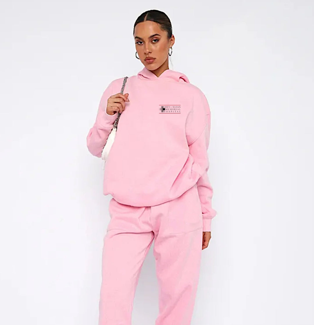 Grey Sloan Memorial Hospital Pink Hoodie - A vibrant pink hoodie featuring the iconic logo of Grey Sloan Memorial Hospital, perfect for fans who want a stylish and cozy way to represent their favorite medical series.