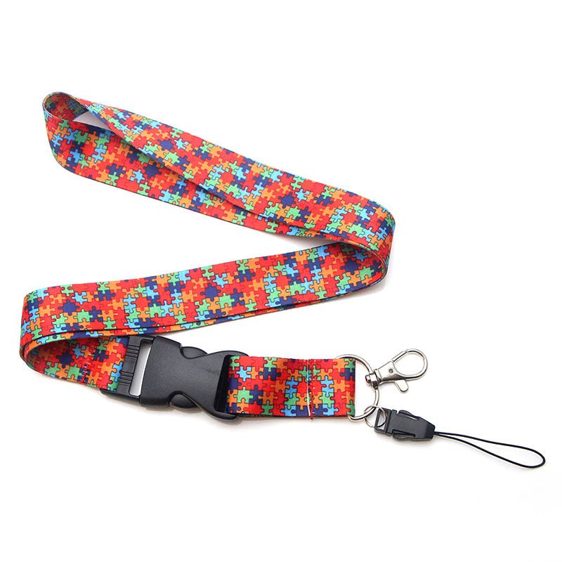 Colorful lanyard featuring a jigsaw puzzle piece design in red, blue, and green, symbolizing autism and neurodiversity awareness.