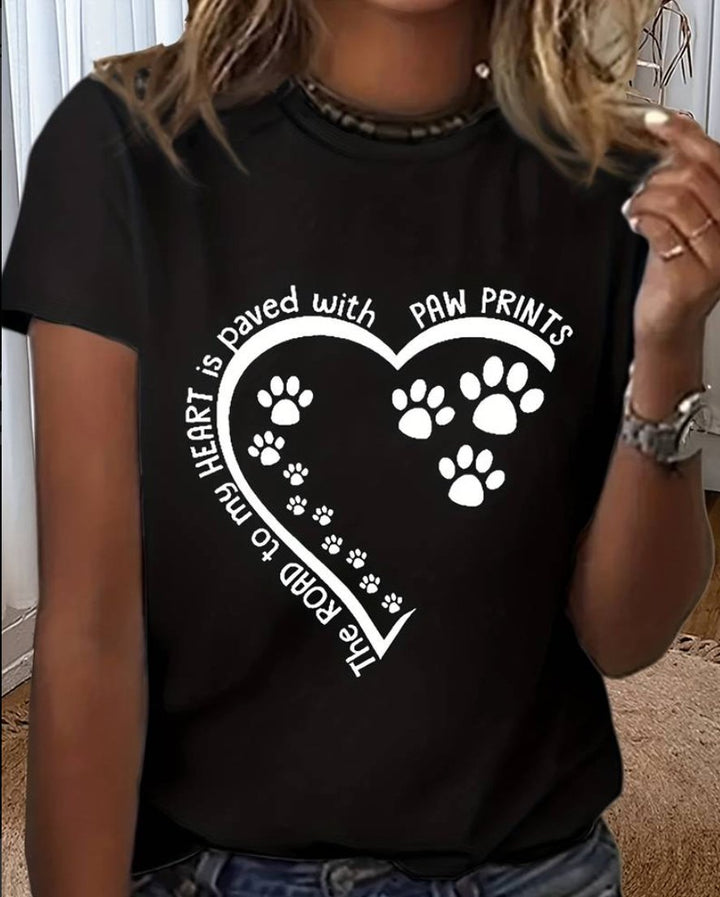 A black t-shirt with a white heart design that has paw prints inside. The text "The road to my heart is paved with paw prints" is written around the heart. This shirt is a perfect choice for any veterinarian who loves animals and especially for those who love dogs. 