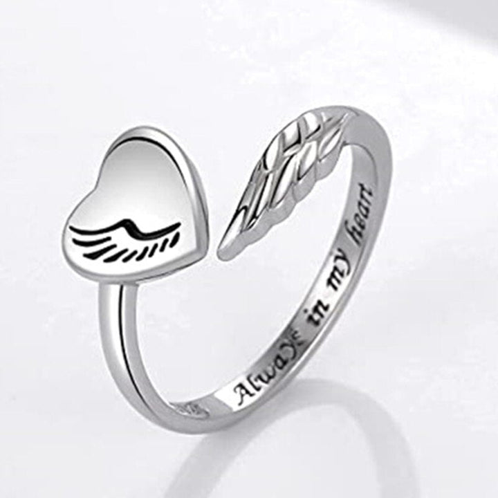 Silver heart shaped ring with angels wings enclosing it. Engraved with 'Always In My Heart'