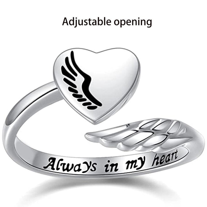 Silver heart shaped ring with angels wings enclosing it. Engraved with 'Always In My Heart'. Showing adjustable opening