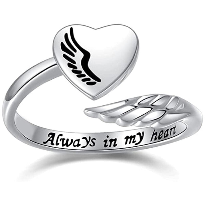 A silver ring with a heart-shaped top that has an angel wing design inside of it. The band of the ring has another angel wing and the inscription "Always in my heart".  It is a great gift for someone who has lost a loved one. 